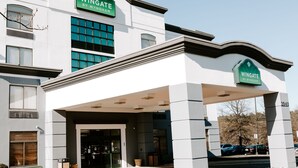 A hotel entrance with a sign reading "Wingate by Wyndham."