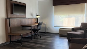 Quarto moderno com escrivaninha, cadeira e sofá.