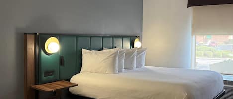 Una cama bien hecha con sábanas blancas y un cabecero con iluminación integrada.