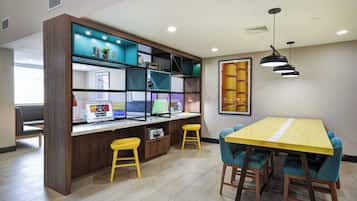 Un interior moderno con un escritorio de madera, dos taburetes amarillos, una mesa amarilla y una estantería con diversos objetos.