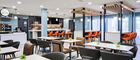 A modern restaurant with multiple seating areas, including tables and booths, and a bar counter.