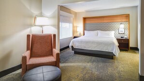 A hotel room with a bed, a chair, a nightstand, and a lamp. - Holiday Inn Allentown-Bethlehem by IHG (Allentown)