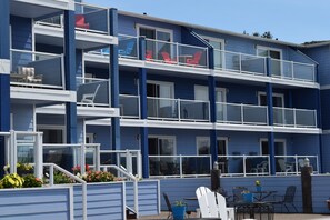 A multi-story hotel with balconies, outdoor seating, and potted plants. - The Landing at Newport (Newport)