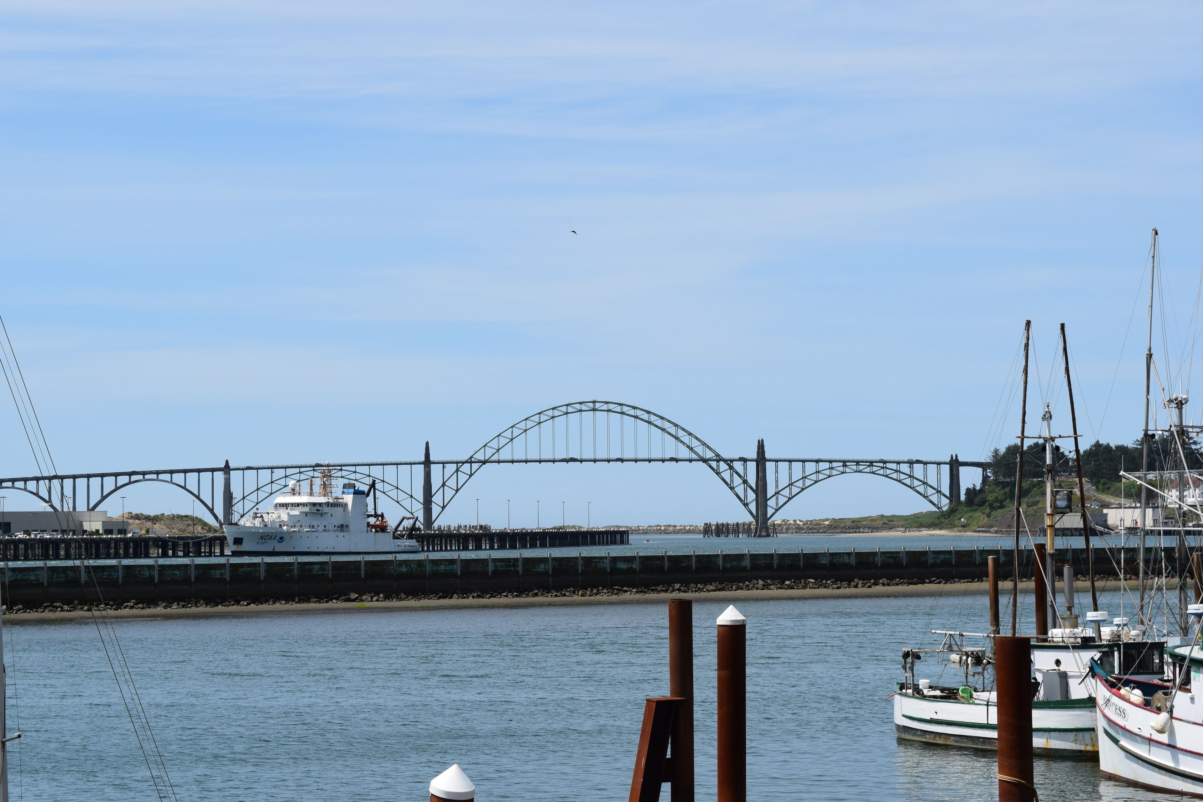 A harbor with boats, a bridge, and a ship docked.