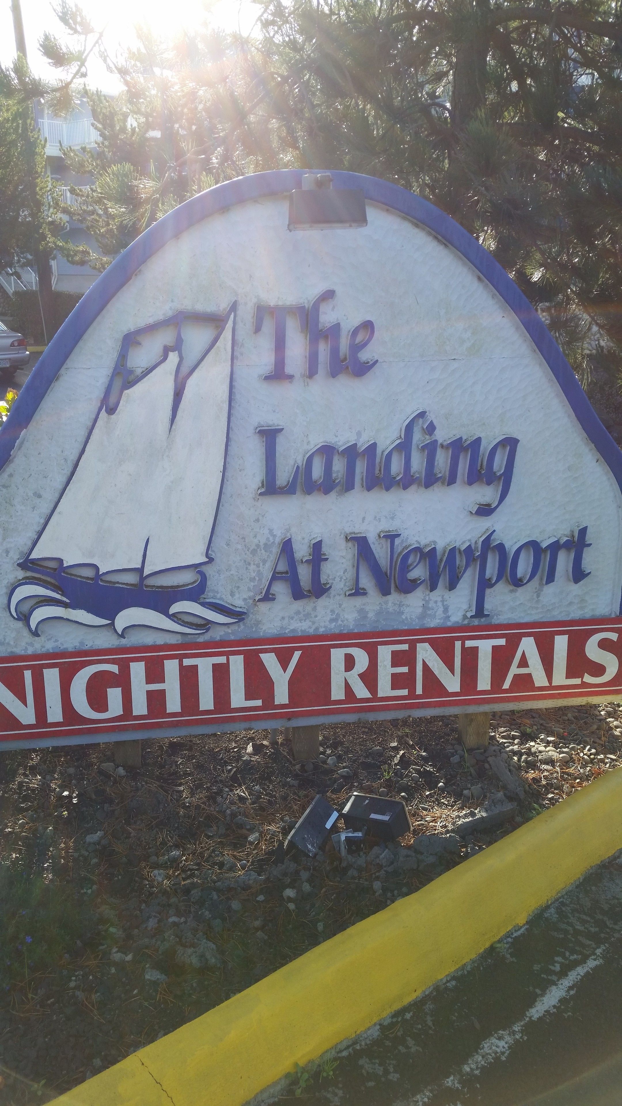 Letrero de 'The Landing At Newport' con un gráfico de un velero y la indicación 'Alquileres Nocturnos'.