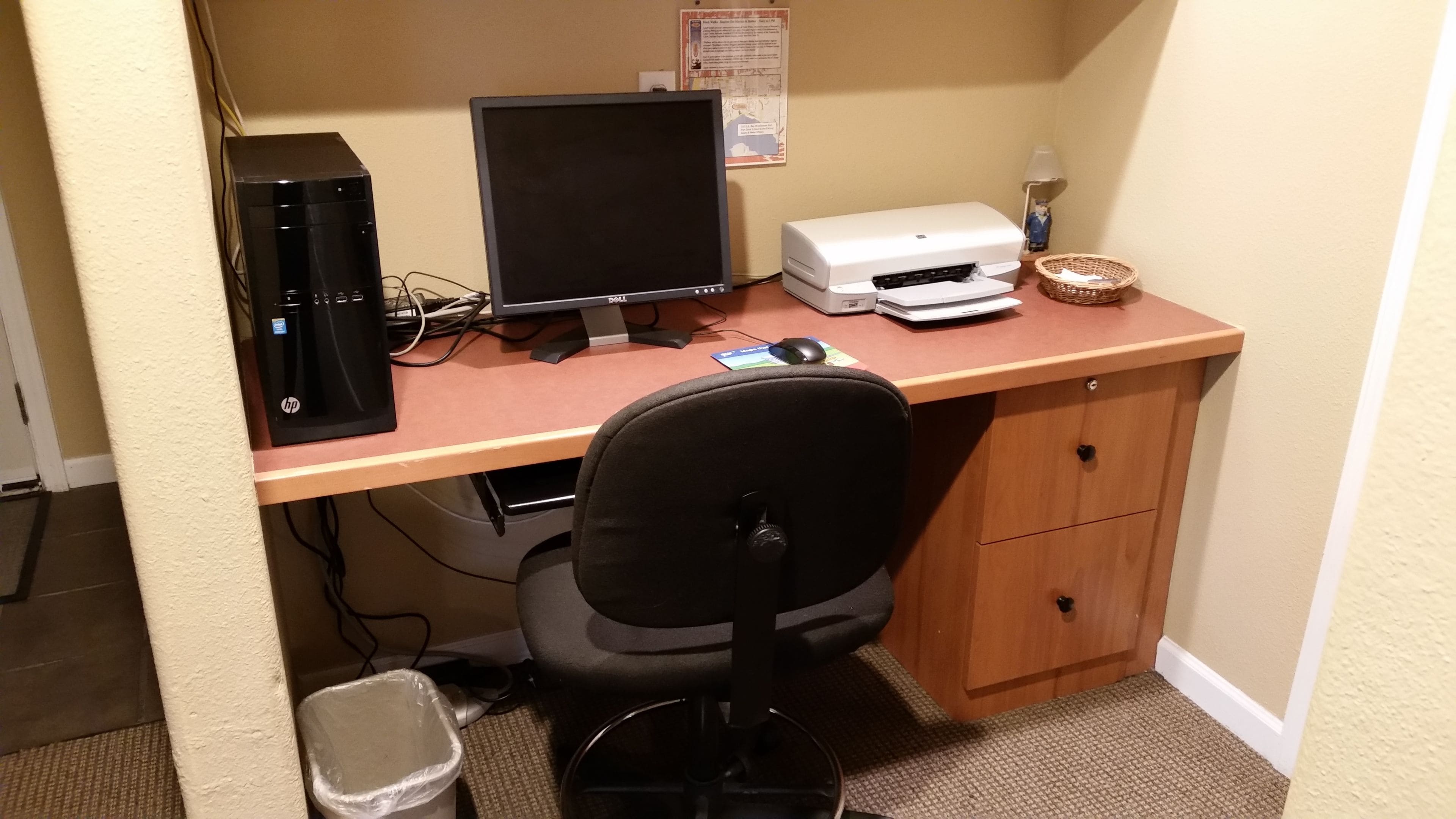 Ein Home-Office-Arbeitsplatz mit Schreibtisch, Computer, Drucker und Bürostuhl.