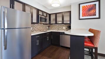 Una cocina compacta equipada con refrigerador, microondas y lavavajillas.