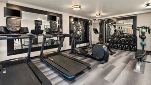 A gym with treadmills, elliptical machines, and weightlifting equipment.