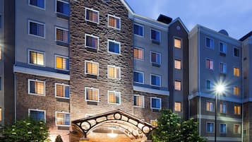 A multi-story hotel with a stone facade, multiple windows, and a covered entrance.