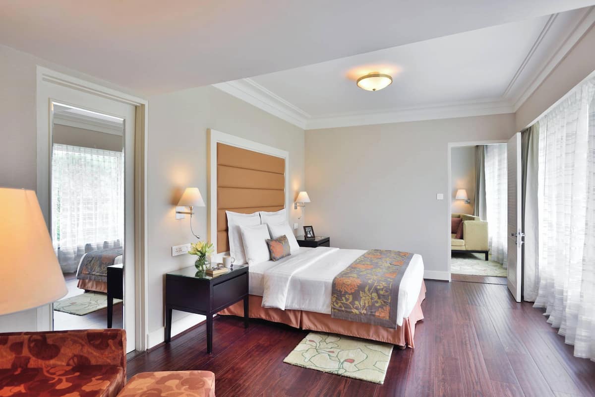 A hotel room with a large bed, bedside tables, a desk, and a chair.