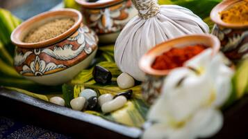 A tray with various containers and a large bulbous object, possibly a spice or ingredient, surrounded by decorative bowls and stones.
