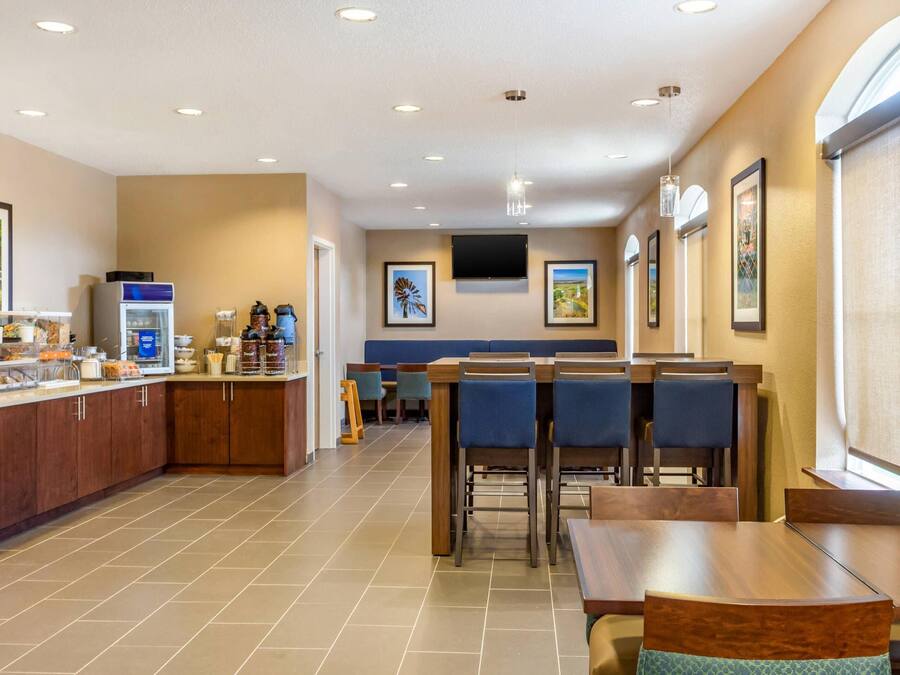 A hotel dining area with a buffet, seating, and artwork on the walls.