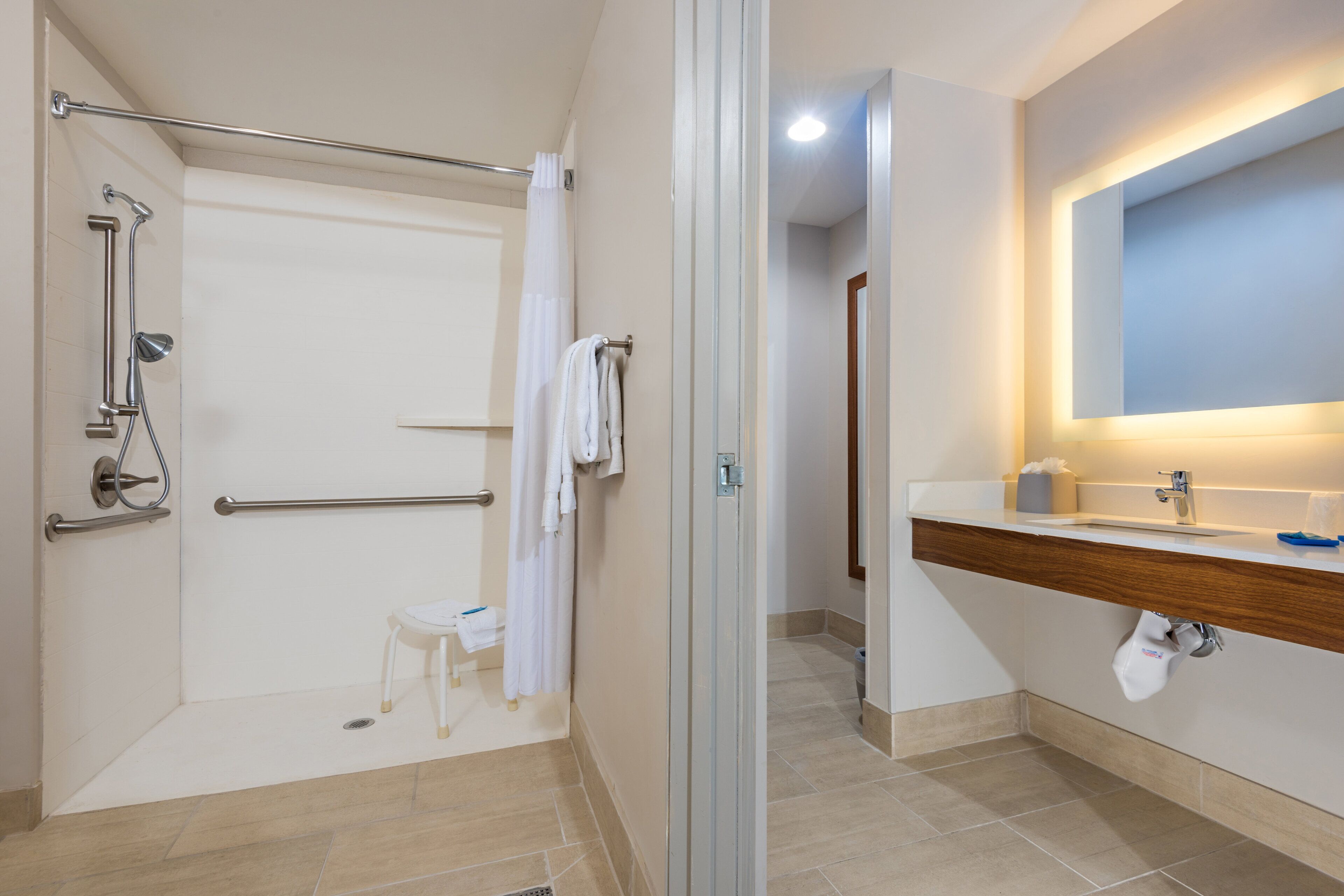 A modern bathroom with a shower, a toilet, and a sink.