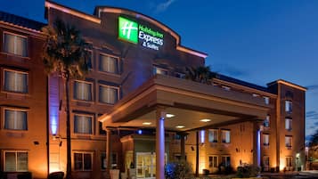 A Holiday Inn Express hotel with a covered entrance, multiple windows, and a sign indicating the hotel's name.