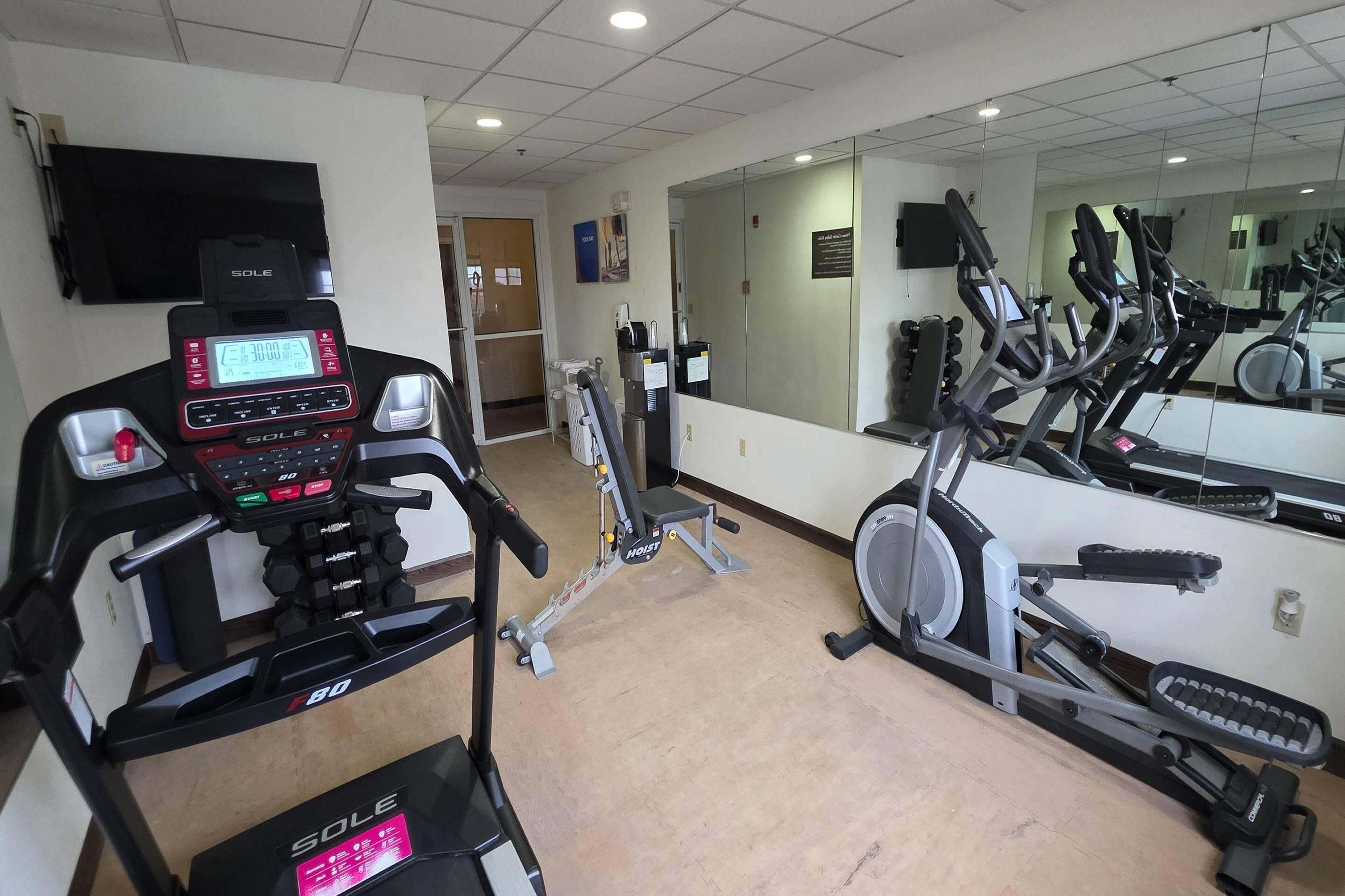 A gym with treadmills, stationary bikes, and weight machines.