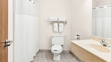 A bathroom with a toilet, a sink, a towel rack, and a shower curtain.