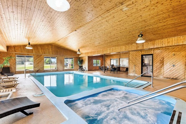 Een binnenzwembad, ligstoelen bij het zwembad