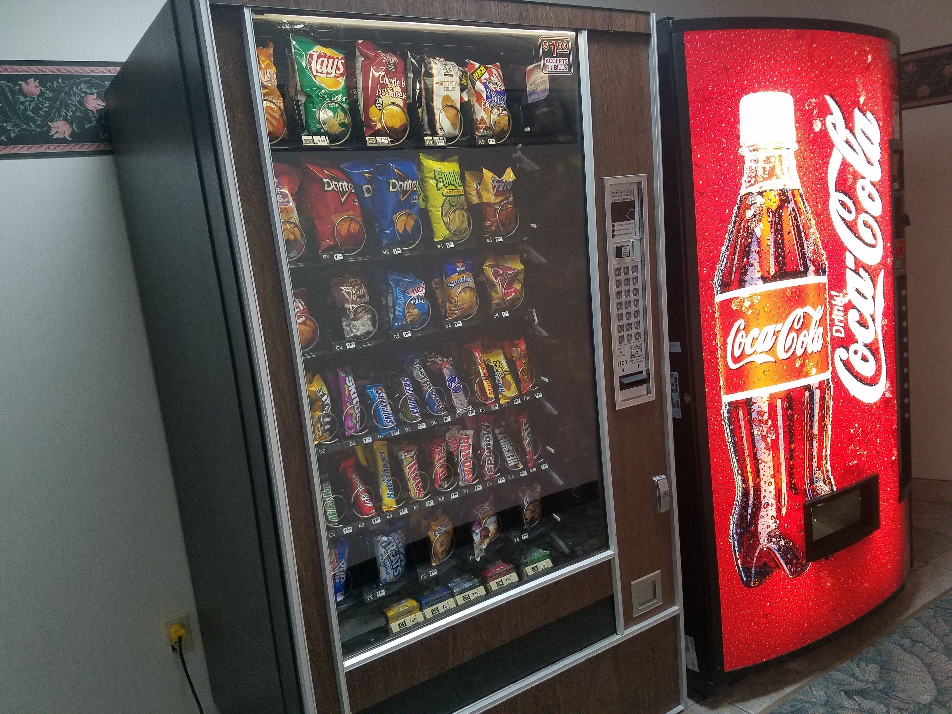 A vending machine with snacks and a Coca-Cola dispenser.