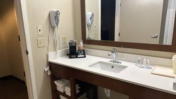 En-suite bathroom with a sink, mirror, and towel rack.