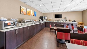 Una cucina d'hotel moderna con un'area buffet, che include una postazione caffè e diversi alimenti.