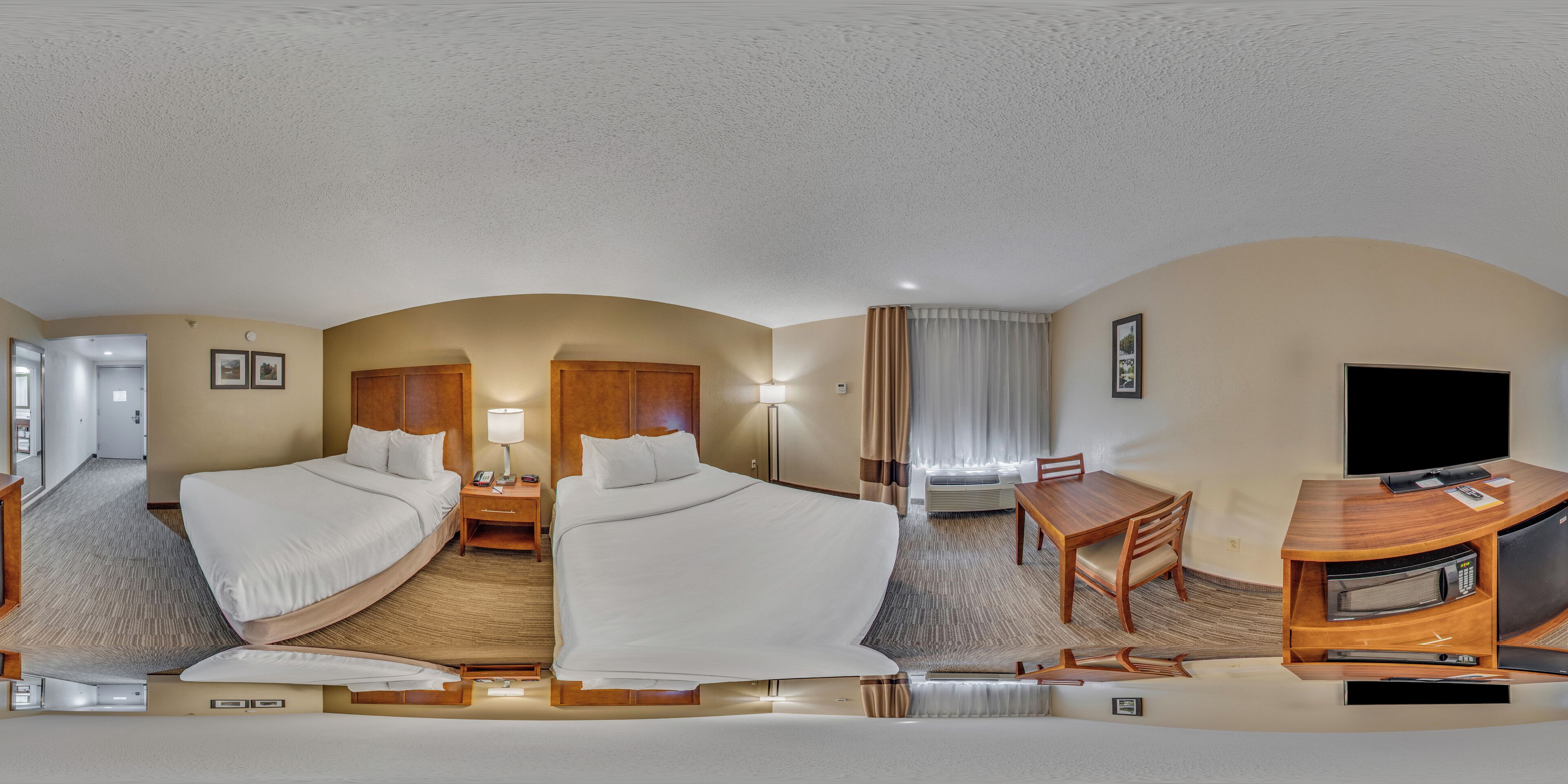 A panoramic view of a hotel room with two beds, a desk, a TV, and a minibar.