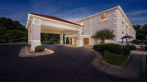 Un hotel Comfort Inn & Suites con ingresso coperto, parcheggio e aree verdi curate.