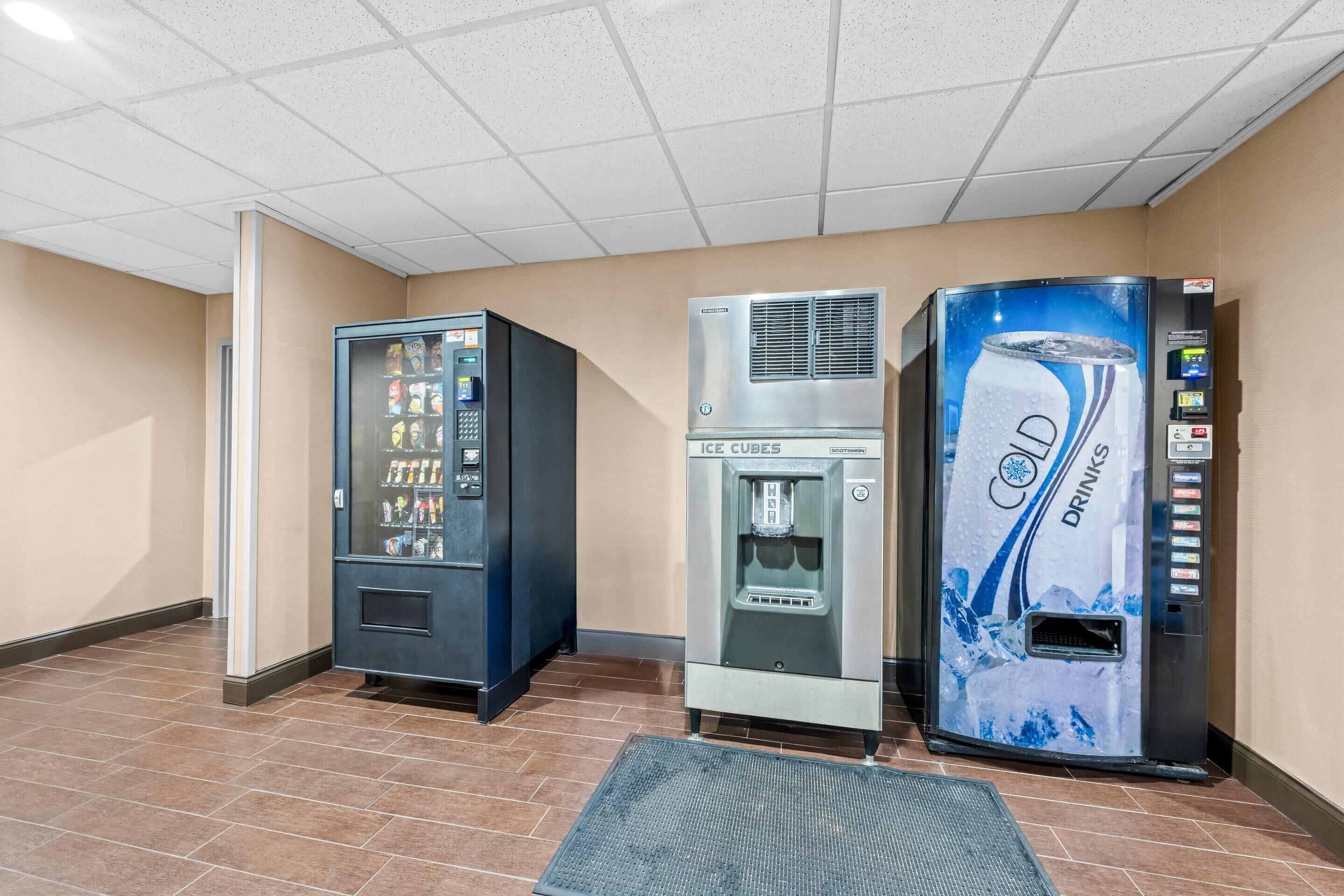 A vending area with a drink dispenser, a water cooler, and a beverage vending machine.