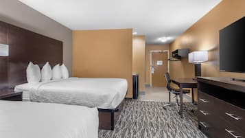 A hotel room with a bed, a desk, a chair, a TV, and a wardrobe.