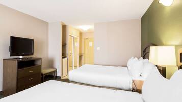Habitación de hotel con dos camas, televisor, escritorio y una silla.