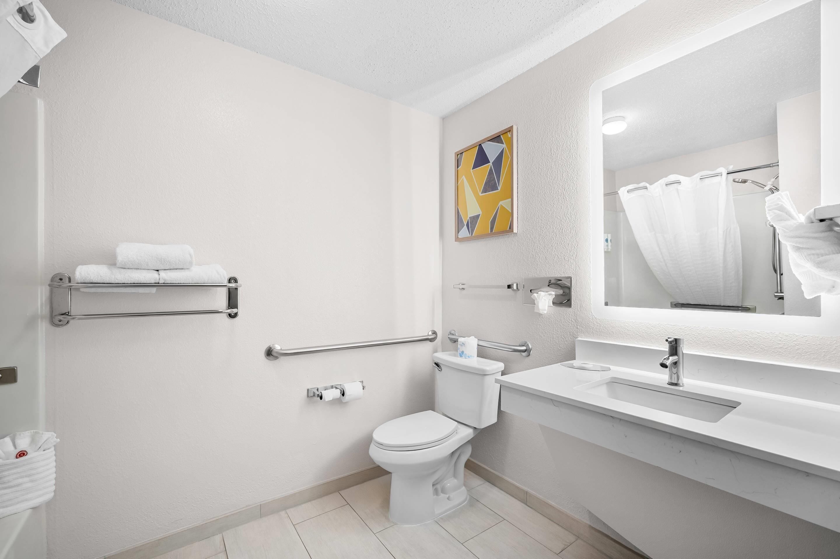 Ein modernes Badezimmer mit Toilette, Waschbecken und Duschbereich.