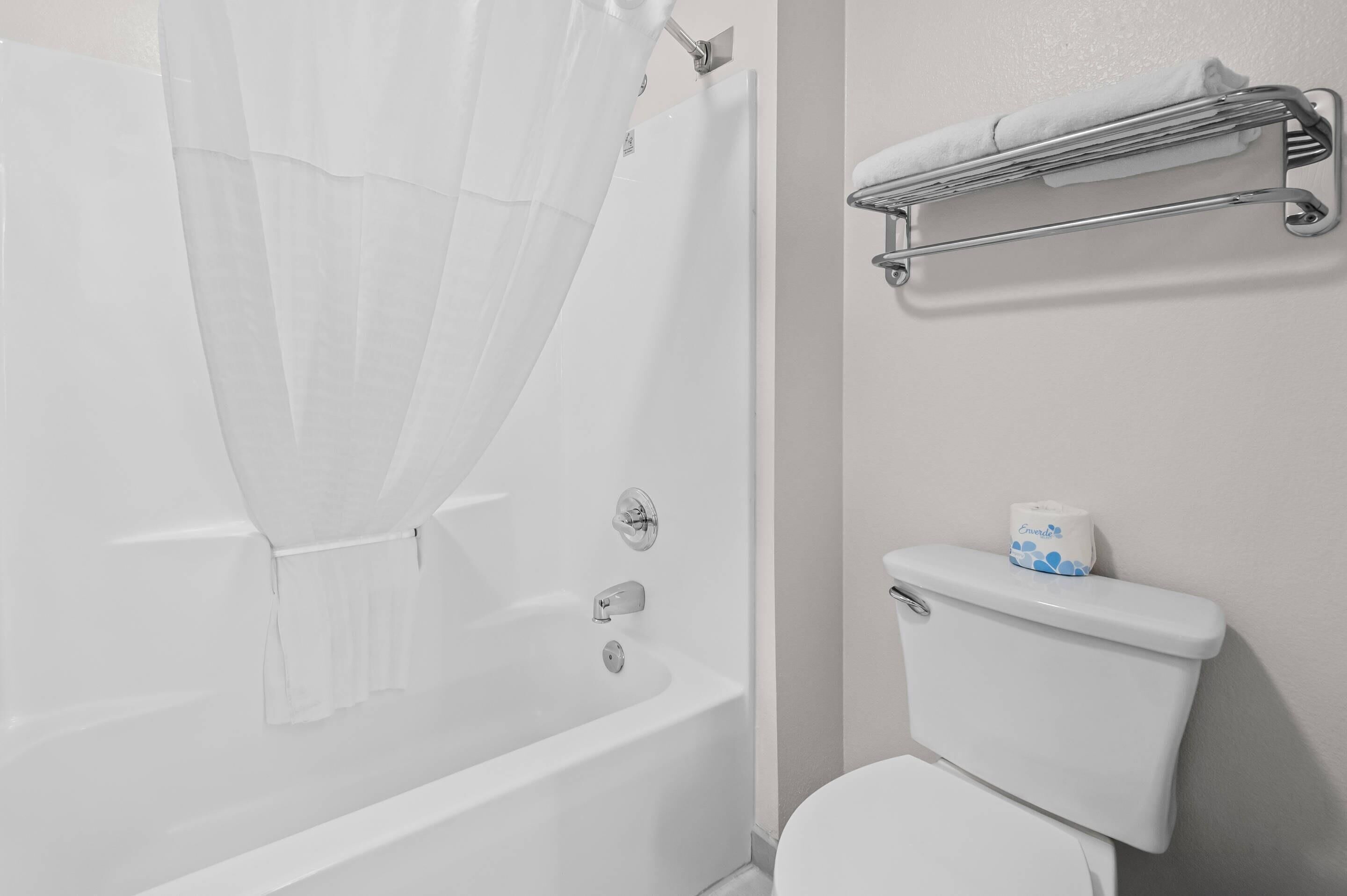 Une salle de bain avec une baignoire, des toilettes et un porte-serviettes.