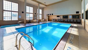 An indoor swimming pool with clear markings, a lifeguard chair, and a seating area with tables and chairs. - Quality Inn & Suites Lubbock South (Lubbock)