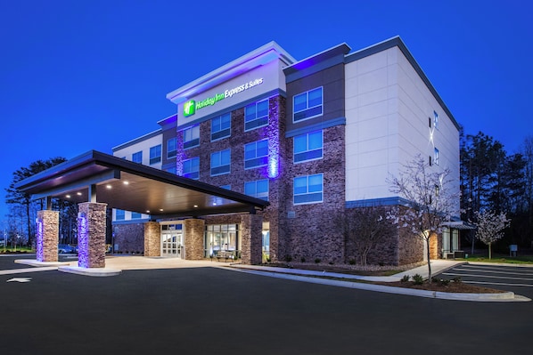 A Holiday Inn Express building with a stone facade, a covered entrance, and a parking lot. - Holiday Inn Express Hotel & Suites Murray by IHG (Murray)