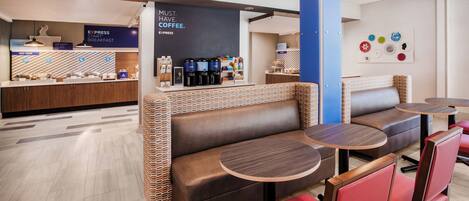 A modern coffee shop with seating areas, a coffee station, and a breakfast counter.