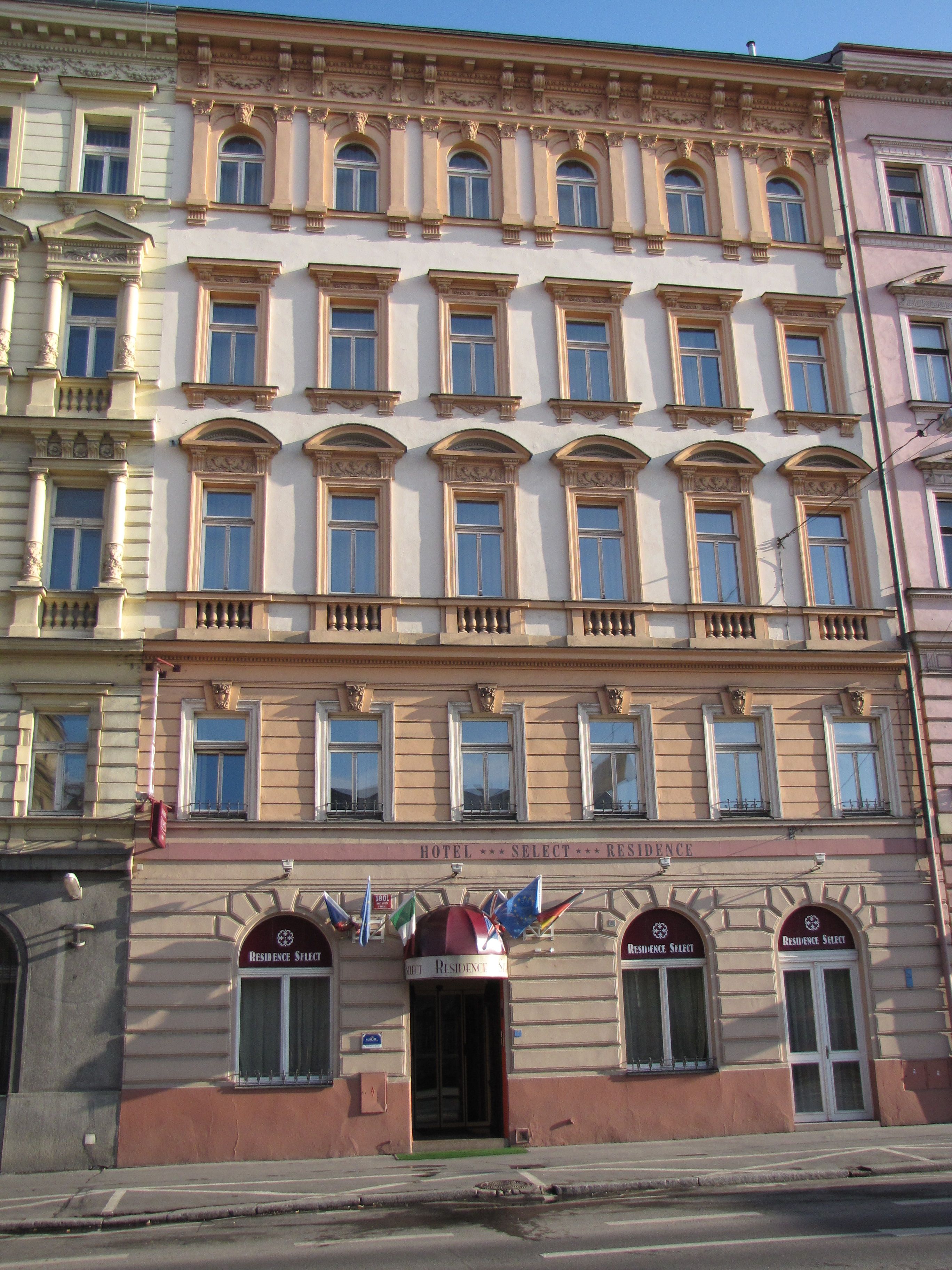 A multi-story hotel with a classic architectural style, featuring arched windows and decorative moldings.