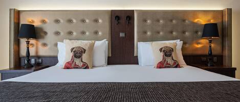 A hotel room with a large bed, two nightstands, and a headboard with a textured design.