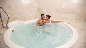 A couple in a hot tub with a tiled wall and a metal ladder. - Barceló San José (San José)