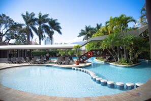 A swimming pool with lounge chairs and palm trees. - Barceló San José (San José)