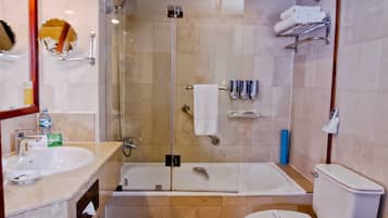 A modern bathroom with a glass-enclosed shower, a bathtub, a toilet, and a sink.