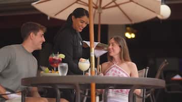 A table with a drink, a menu, and a dessert.