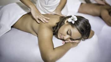 A person receiving a massage on a white massage table in a spa setting.