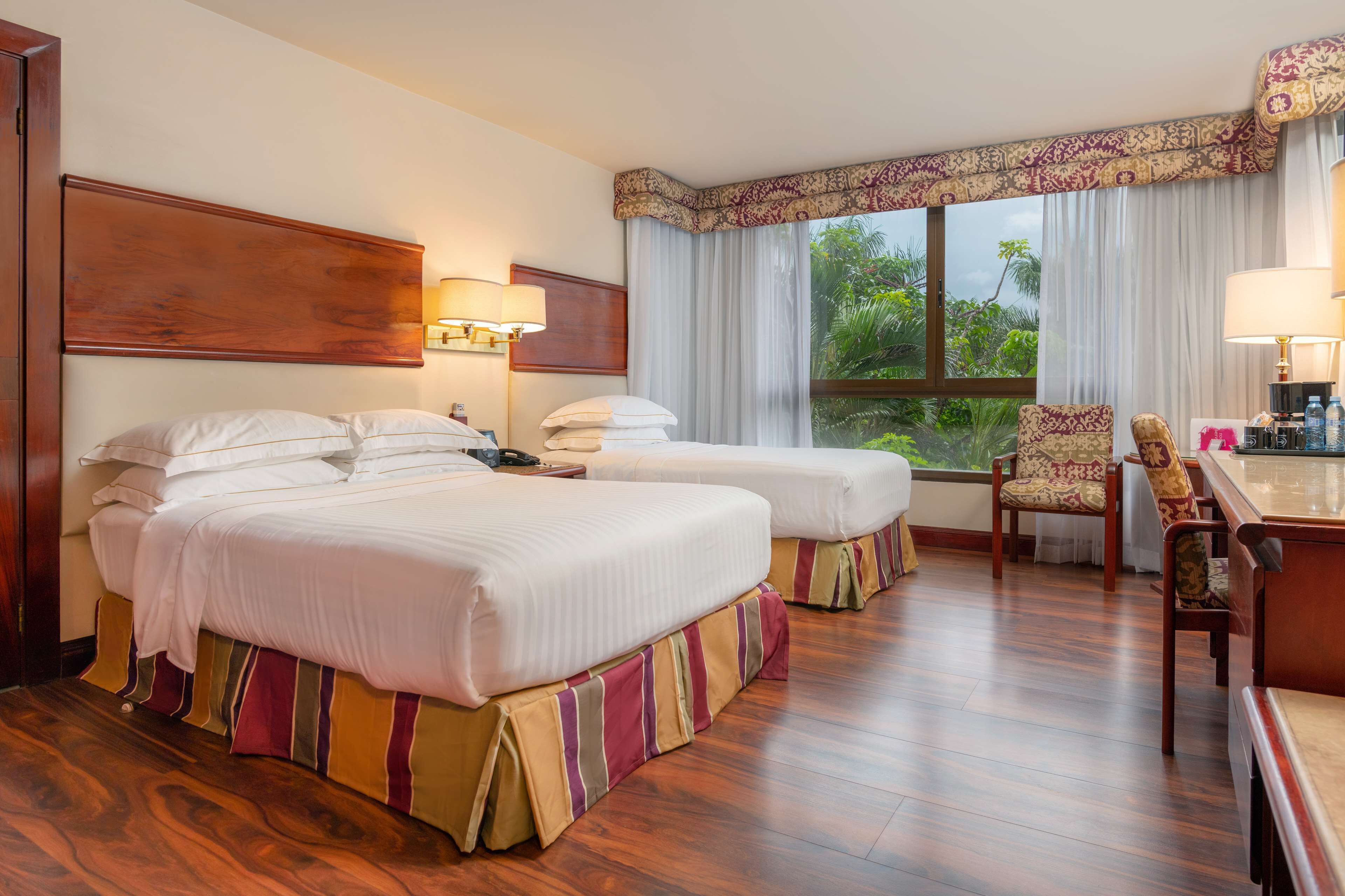 Una habitación de hotel con dos camas, un escritorio y una silla.