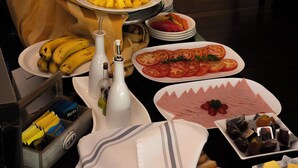 Una mesa de buffet con diversos alimentos, entre ellos frutas, verduras y carnes.