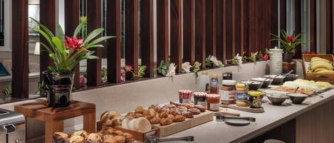 Um buffet com diversos alimentos e acompanhamentos.