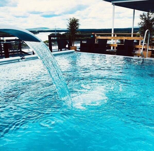 Piscine extérieure en saison, chaises longues