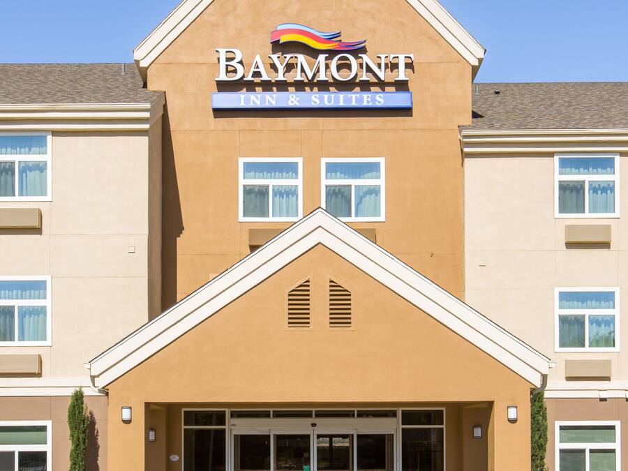 Et Baymont Inn & Suites hotel med tydelig skiltning, store vinduer og parkeringsplads.