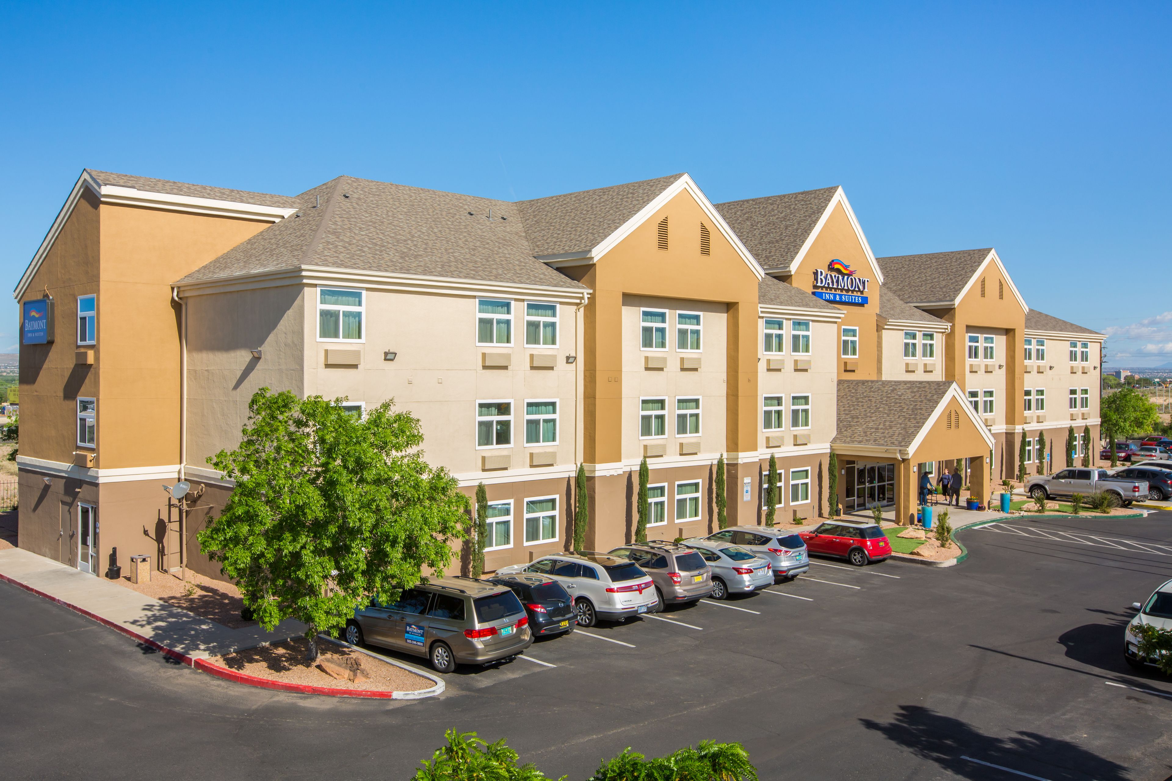 A multi-story hotel with a parking lot in front.