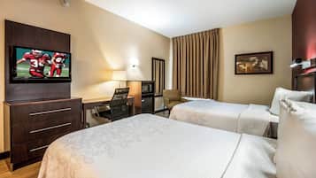 A hotel room with two beds, a TV, a desk with a chair, a lamp, a microwave, and a painting on the wall.