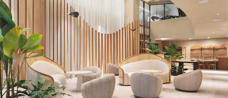 A modern lobby with a seating area featuring round and curved sofas, a high ceiling with recessed lighting, and a decorative wall with vertical wooden slats.