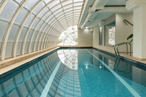 An indoor swimming pool with a curved ceiling and clear glass panels. - QOYA Hotel Curitiba, Curio Collection by Hilton (Curitiba)